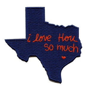 Op de afbeelding: Een blauwe viltpatch in de vorm van de staat Texas met de woorden "Ik hou van je zo veel" geborduurd in rode draad. Een klein rood hartje is ook geborduurd in de rechter benedenhoek.