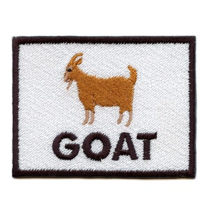 Könnte beinhalten: Ein weißer gestickter Aufnäher mit einer braunen Ziege und dem Wort "GOAT" in schwarzen Buchstaben.