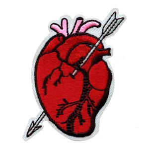 May include: Red embroidered heart with a black outline and a white arrow piercing through it. The arrow has a gray tip and a pink feather.