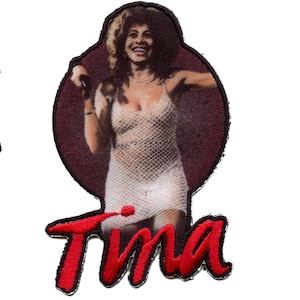 May include: A red embroidered patch with a photo of a woman singing into a microphone. The woman is wearing a white dress and has long brown hair. The text "Tina" is embroidered in red below the photo.