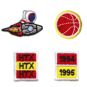 Puede incluir: Cuatro parches bordados para planchar. Un parche presenta una pelota de baloncesto roja y blanca. Un parche presenta un cohete rojo, blanco y gris. Dos parches presentan rectángulos rojos y amarillos con el texto "HTX" y "1994, 1995" respectivamente.
