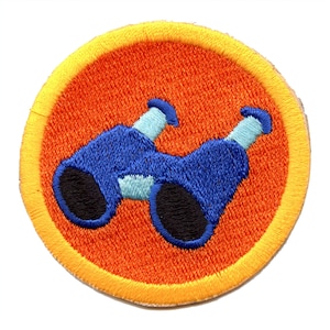 May include: A round, orange and yellow embroidered patch with a blue pair of binoculars in the center.