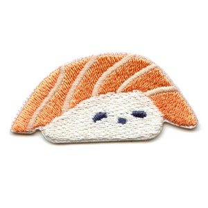 May include: A white and orange embroidered patch of a sushi roll with a cute face.