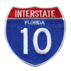 Puede incluir: Señal de carretera interestatal azul y roja con el número 10 y el texto "INTERSTATE" y "FLORIDA" en blanco.