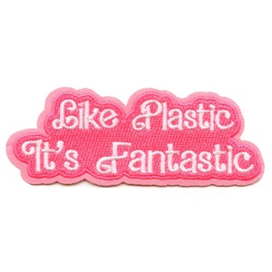 Könnte beinhalten: Rosa gestickter Aufnäher mit weißem Text, der "Like Plastic It's Fantastic" lautet.
