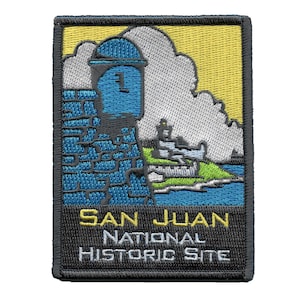 May include: Embroidered patch featuring a yellow, blue, and green illustration of a fort with a tower and a cloud. The text "SAN JUAN NATIONAL HISTORIC SITE" is below the illustration.