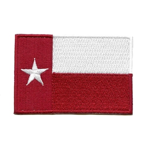 May include: A red and white embroidered patch featuring the Texas state flag. The flag has a single white star on a red background, with a white horizontal stripe below.