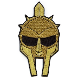 Könnte beinhalten: Gold gestickter Aufnäher eines römischen Gladiatorenhelms mit schwarzem Visier und einem spitzen Kamm.