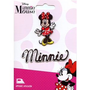 May include: Iron-on patch featuring Minnie Mouse in a red dress with white polka dots. The patch includes the word "Minnie" in a white outline with black lettering. The packaging includes the text "Disney Minnie Mouse" and "Appliqué | Aplicación".