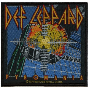 Könnte beinhalten: Ein gewebter Patch mit schwarzem Hintergrund, der das Logo der Band Def Leppard in Gelb und Rot mit den Worten "Pyromania" in Rot und Gelb unter dem Logo zeigt. Das Logo ist vor einem blauen und grauen Hintergrund mit einem Ziel und Flammen in der Mitte platziert.