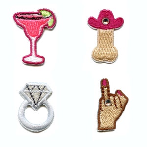 Pode incluir: Quatro patches bordados para passar a ferro: um copo de margarita rosa, um chapéu de cowboy rosa sobre um osso castanho, um anel de prata com um diamante e uma mão castanha com um dedo rosa apontando para cima.