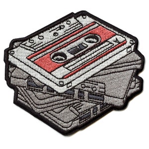 May include: A stack of vintage audio cassette tapes with a red and white cassette on top. The tapes are embroidered in gray and black thread.