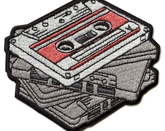 May include: A stack of vintage audio cassette tapes with a red and white cassette on top. The tapes are embroidered in gray and black thread.
