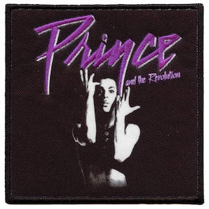 May include: Purple and white embroidered patch with the text "Prince and the Revolution". The patch features a black and white image of Prince.