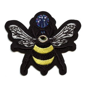May include: Black embroidered patch of a bee with a single large eye and a colorful, patterned crown on its head.