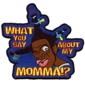 May include: Embroidered patch with a cartoon character with a surprised expression. The character has brown skin, a large nose, and a wide mouth. The text "What you say about my momma!" is written around the character.