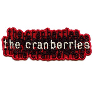 May include: Red embroidered patch with the text "the cranberries" in black and white lettering.