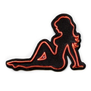 May include: A black iron-on patch with a red outline of a woman's silhouette. The woman is lying on her side with her arm bent and her hand resting on her chin.