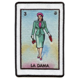 Könnte beinhalten: Eine Spielkarte im Vintage-Stil mit einer Frau in einem grünen Anzug und einem rosa Hut. Die Karte ist mit "3" und "LA DAMA" beschriftet.