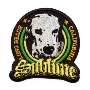 May include: A brown, green, and yellow embroidered patch with a dalmatian dog's face in the center. The text "Sutlline" is below the dog's face. The text "Long Beach California" is around the dog's face.