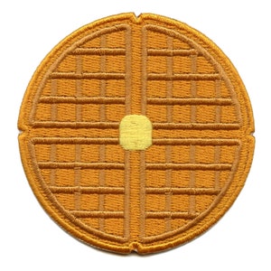 May include: A brown embroidered waffle patch with a yellow circle in the centre, representing a pat of butter.