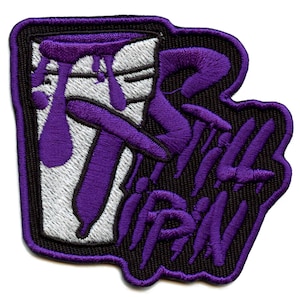 May include: Purple and white embroidered patch with a stylized image of a cup with a purple liquid dripping from it and the text "Still Tippin".