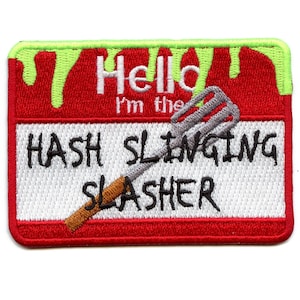 May include: Red and white embroidered patch with green dripping paint at the top. The patch says "Hello I'm the HASH SLINGING SLASHER" with a silver whisk and brown handle sticking out of the bottom.