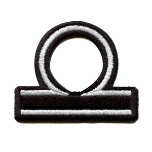 May include: Black and white embroidered iron-on patch of the astrological symbol for Libra.