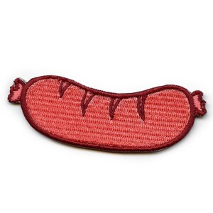 Könnte beinhalten: Ein roter gestickter Aufnäher in Form einer Wurst mit braunem Umriss.