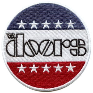 May include: Circular embroidered patch with the band name "The Doors". The design features a blue top section with white stars, a white middle section with the band name, and a red bottom section with white stars.