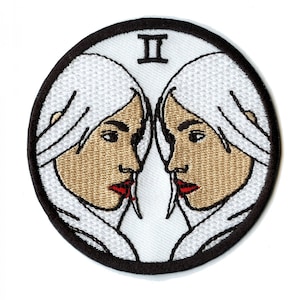 May include: Embroidered patch depicting the Gemini zodiac sign. The design features two profiles facing each other, with white hair and red lips. The Roman numeral "II" is at the top, within a black circular border.