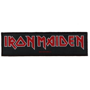 May include: Black and white embroidered patch with the red text "IRON MAIDEN" in a bold, stylized font.