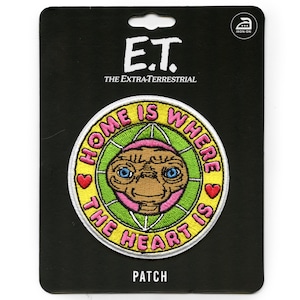 May include: Iron-on patch featuring E.T. the Extra-Terrestrial with the text "Home is where the heart is" in a circle with a green and yellow background.