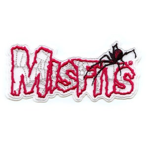以下が含まれることがあります： 蜘蛛の巣のデザインで「MISFITS」という言葉が書かれた、赤と白の刺繍パッチ。黒いクモが言葉の上にいます。