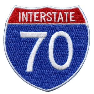 May include: A blue and red interstate highway sign with white text and the number 70.