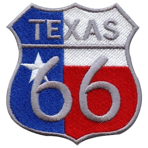May include: A gray and white embroidered patch with the text "TEXAS" and the number "66" in a gray font. The patch is shaped like a shield and features the Texas state flag colors of blue, white, and red.