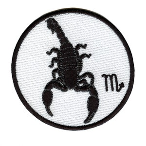 May include: White embroidered patch featuring a black scorpion silhouette and the astrological symbol for Scorpio, "m", in the bottom right corner.