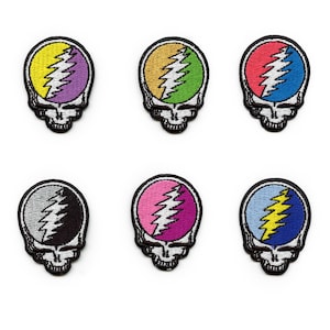 Könnte beinhalten: Sechs gestickte Bügelbilder mit dem legendären Steal Your Face-Logo der Grateful Dead in verschiedenen Farbkombinationen. Die Patches sind alle gleich groß und haben die gleiche Form, mit einem Schädelumriss und einem Blitzdesign.
