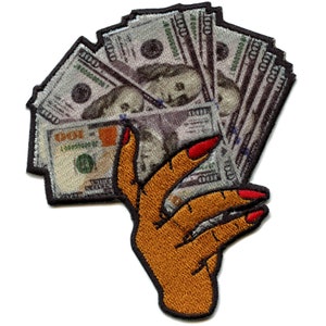 May include: An embroidered patch of a hand holding a fan of US dollar bills. The hand is brown with red nail polish. The bills are gray and white with the denomination "100" printed on them.