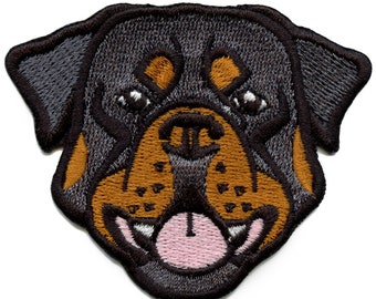 May include: Embroidered patch featuring a Rottweiler dog's face. The patch has a black and brown color scheme with detailed stitching. The dog's mouth is open, revealing a pink tongue and white teeth. The patch is designed to be ironed on or sewn.