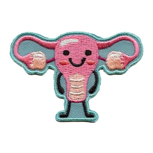 May include: A pink and white embroidered patch of a smiling uterus with arms and legs. The uterus is on a light blue background.