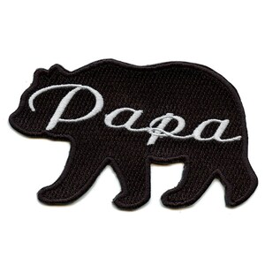May include: Black embroidered iron-on patch featuring a bear silhouette and the word "Papa" in white cursive lettering.