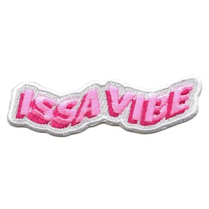 Può includere: Toppa ricamata rosa con il testo "ISSA VIBE" in un font ondulato.