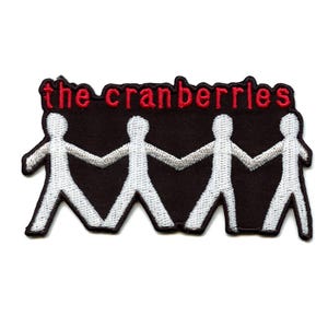May include: White embroidered patch with four stick figures holding hands, with the text "the cranberries" in red above the figures.