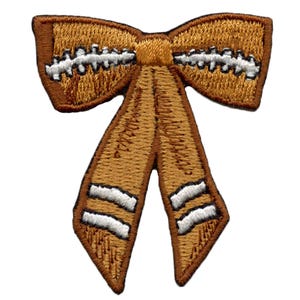 May include: A brown fabric bow with white stitching and two white stripes on each tail. The bow is a decorative embellishment for crafts and sewing projects.