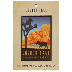 May include: A brown and black embroidered patch featuring a silhouette of a Joshua Tree and a mountain range. The patch reads "Joshua Tree National Park".