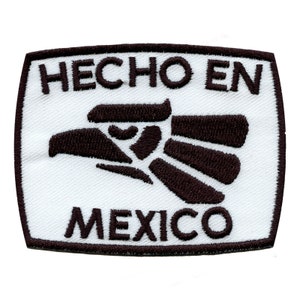 May include: White rectangular patch with black embroidered text "HECHO EN MEXICO" and a stylised black eagle design.