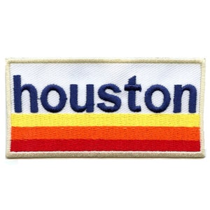May include: A white embroidered patch with the word "houston" in navy blue lettering and a striped design of red, orange, and yellow.