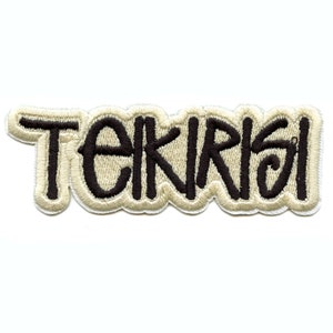 May include: A beige embroidered patch with the word "TEKIRISI" in black lettering.