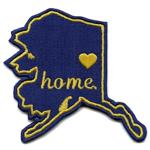 May include: A blue embroidered patch in the shape of Alaska with a gold outline. The patch says "home" in gold lettering and has a gold heart.